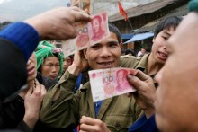 Vietnamese people pay goods in China's renminbi at Dong Van Market which sits along the border of the northern province of Ha Giang.